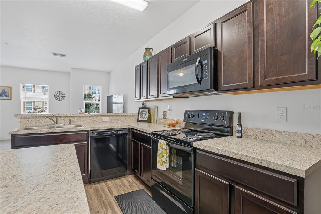 5523 Yellowfin Court New Port Richey, FL 34652 - Photo 18 of 58 a kitchen with stainless steel appliances granite countertop a stove a sink and a microwave