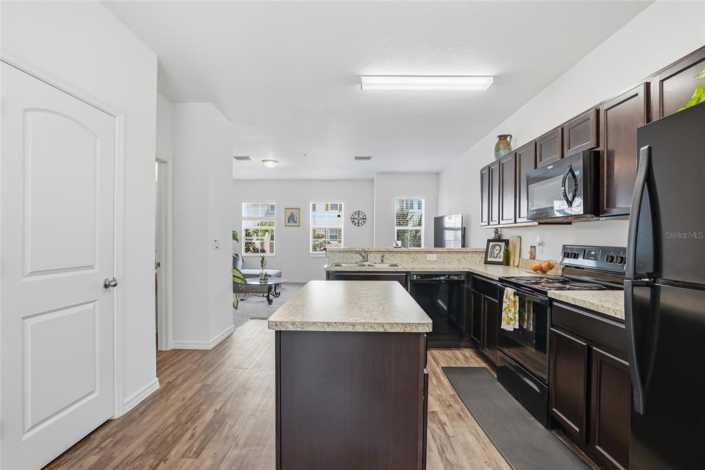 5523 Yellowfin Court New Port Richey, FL 34652 - Photo 19 of 58 a kitchen with stainless steel appliances granite countertop a refrigerator a sink dishwasher a stove and white countertops with wooden floor