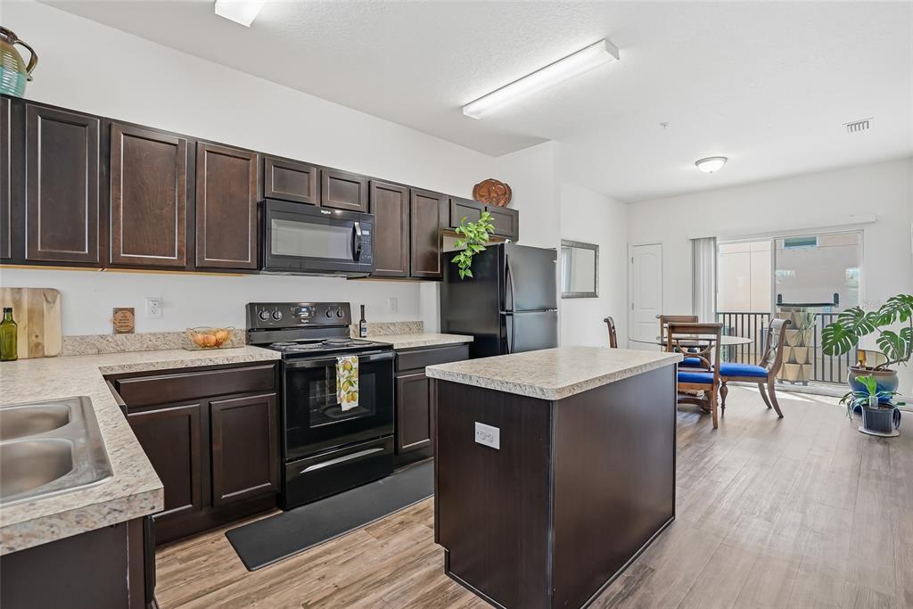 5523 Yellowfin Court New Port Richey, FL 34652 - Photo 21 of 58 a kitchen with stainless steel appliances granite countertop a stove a sink dishwasher and a refrigerator with wooden floor