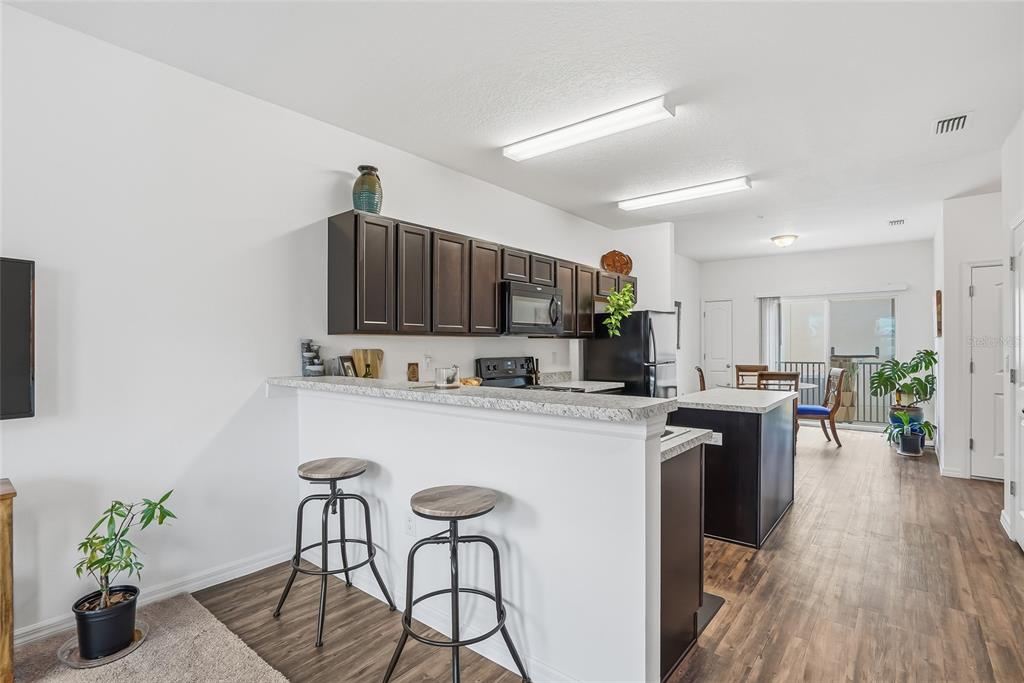 5523 Yellowfin Court New Port Richey, FL 34652 - Photo 24 of 58 a kitchen with kitchen island wooden cabinets and stainless steel appliances