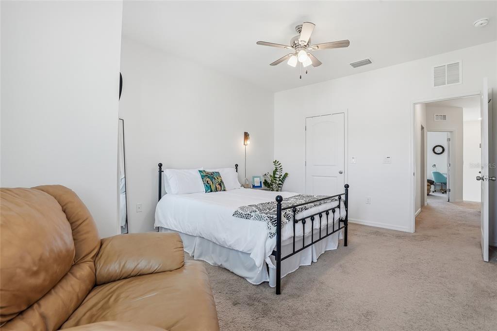 5523 Yellowfin Court New Port Richey, FL 34652 - Photo 37 of 58 a bedroom with a bed a chandelier and a chandelier