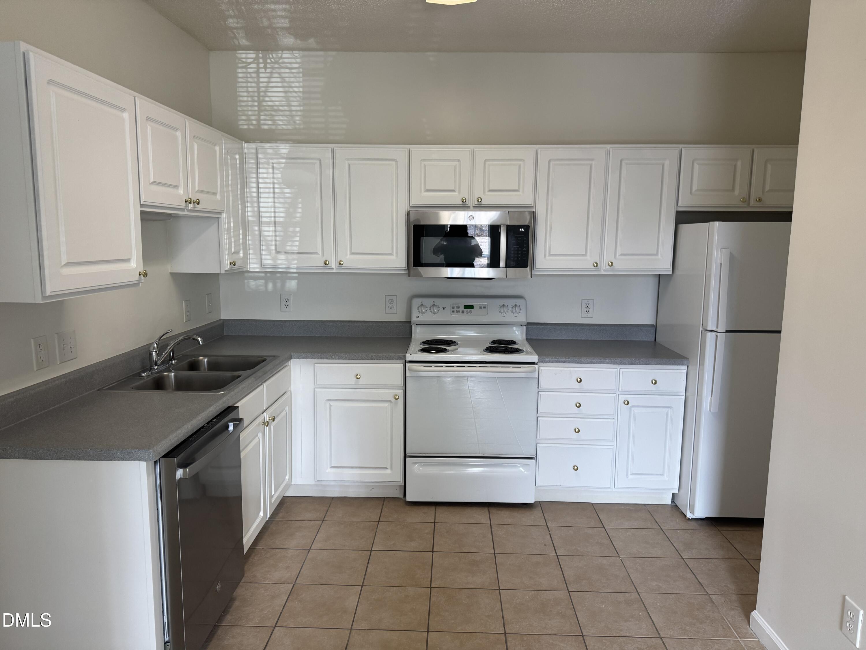 2501 Huntscroft Lane, Unit 201 Raleigh, NC 27617 - Photo 7 of 19 a kitchen with white cabinets and appliances