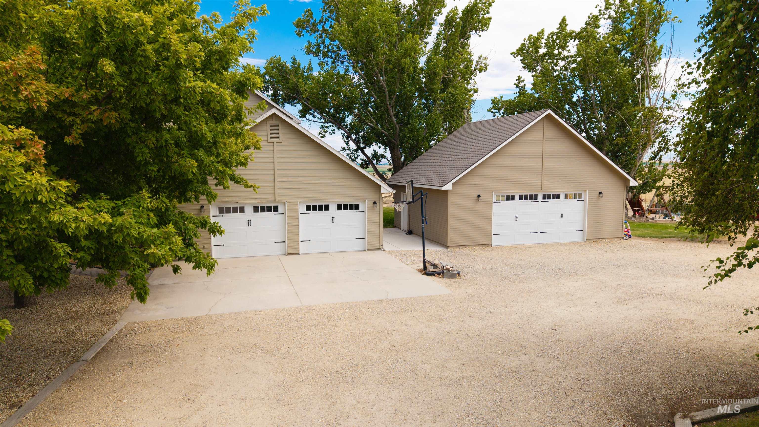 12369 Deer Flat Road Nampa, ID 83686 - Photo 7 of 50 Contemporary kitchen featuring a large central island with a light-toned countertop, white cabinetry with dark hardware, a built-in pantry, open shelving, and wood-finish flooring