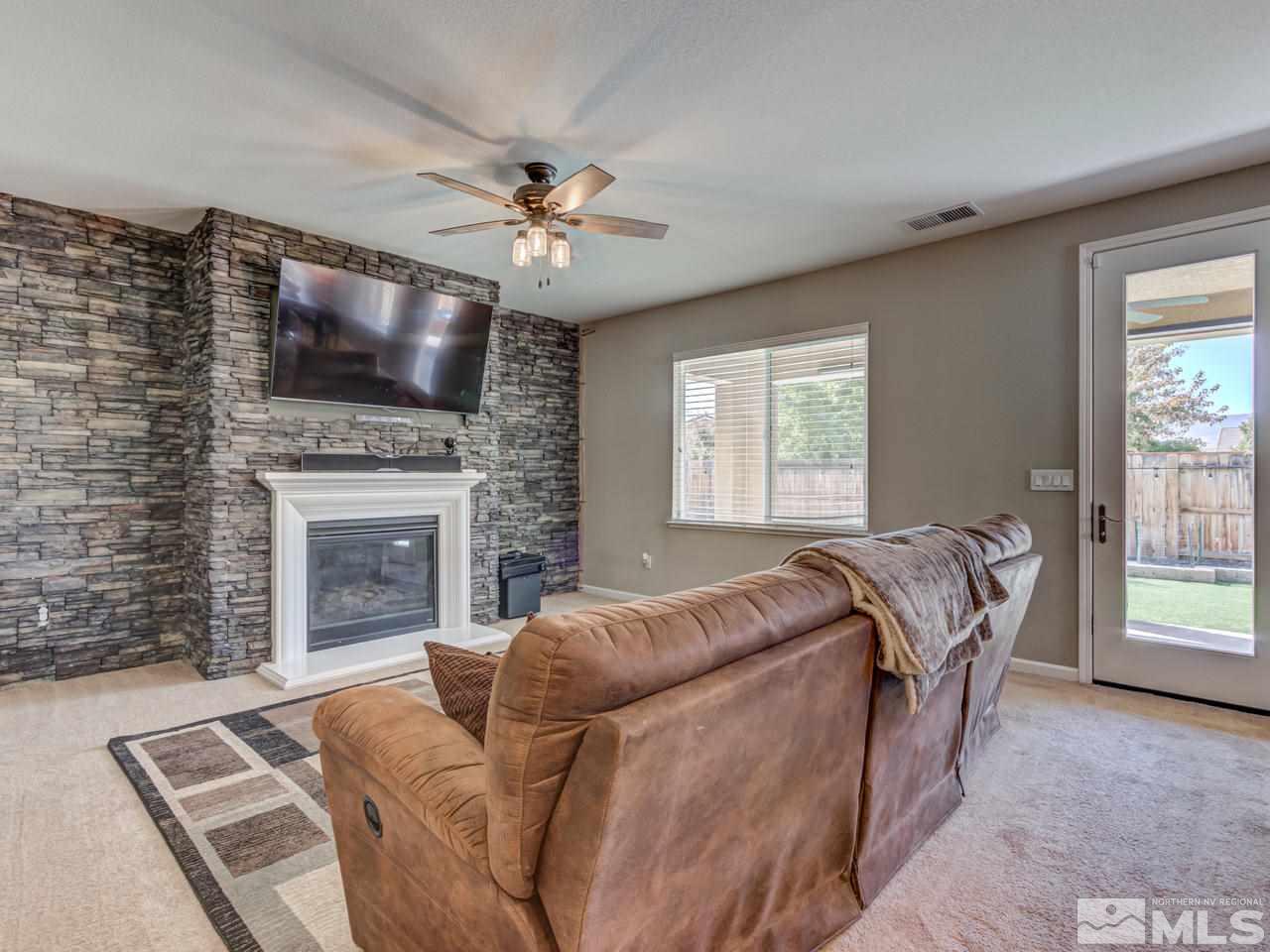 2075 Tawleed Road Reno, NV 89521 - Photo 6 of 24 a living room with furniture a flat screen tv and a fireplace