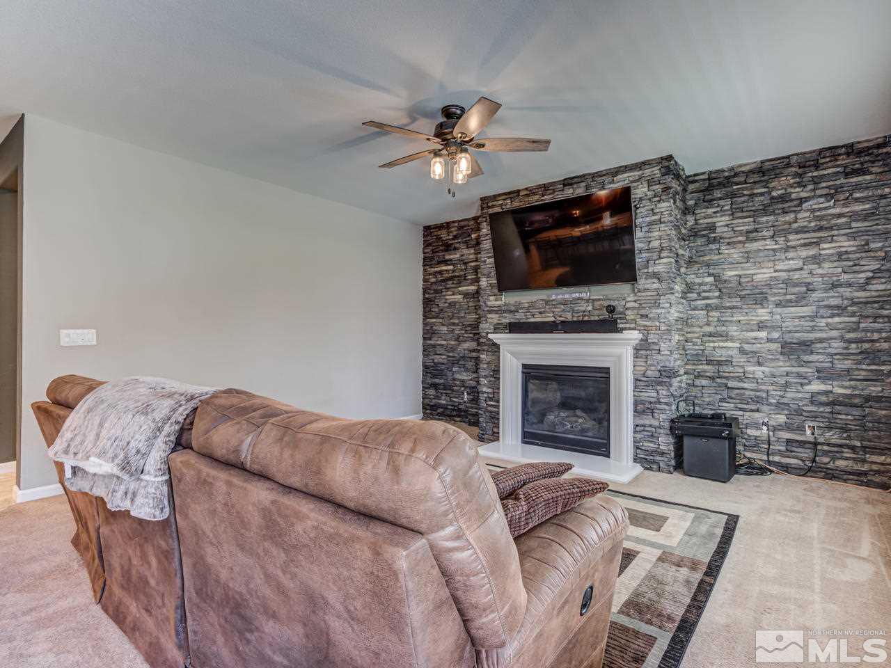 2075 Tawleed Road Reno, NV 89521 - Photo 8 of 24 a living room with furniture a fireplace and a flat screen tv