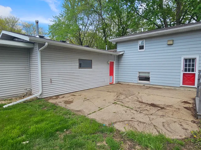a backyard of a house with table and chairs