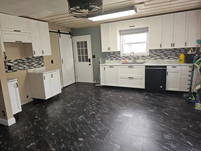 a kitchen with granite countertop white cabinets and white appliances