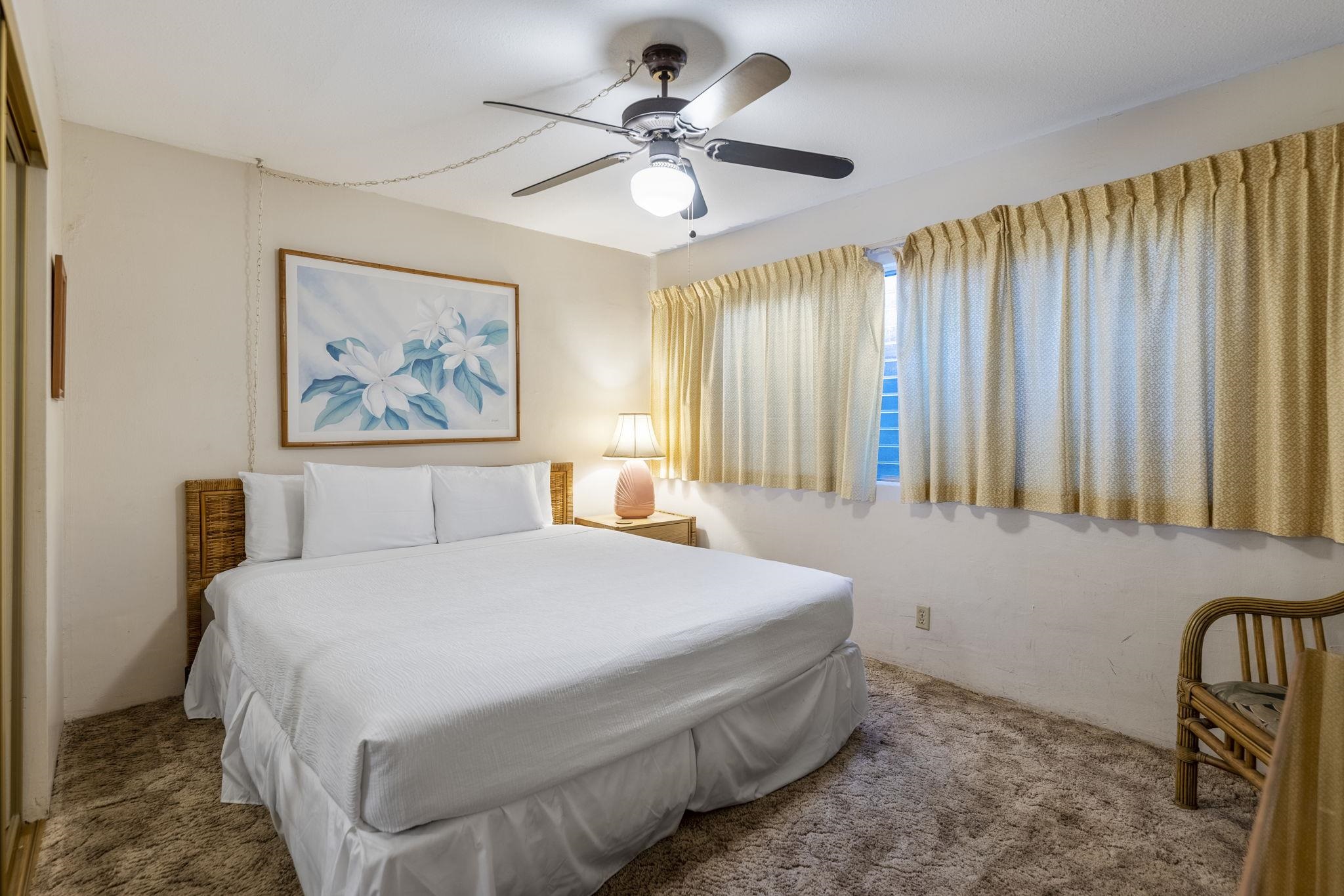 2495 South Kihei Road, Unit 120 Kihei, HI 96753 - Photo 14 of 40 a bedroom with a bed and a chandelier