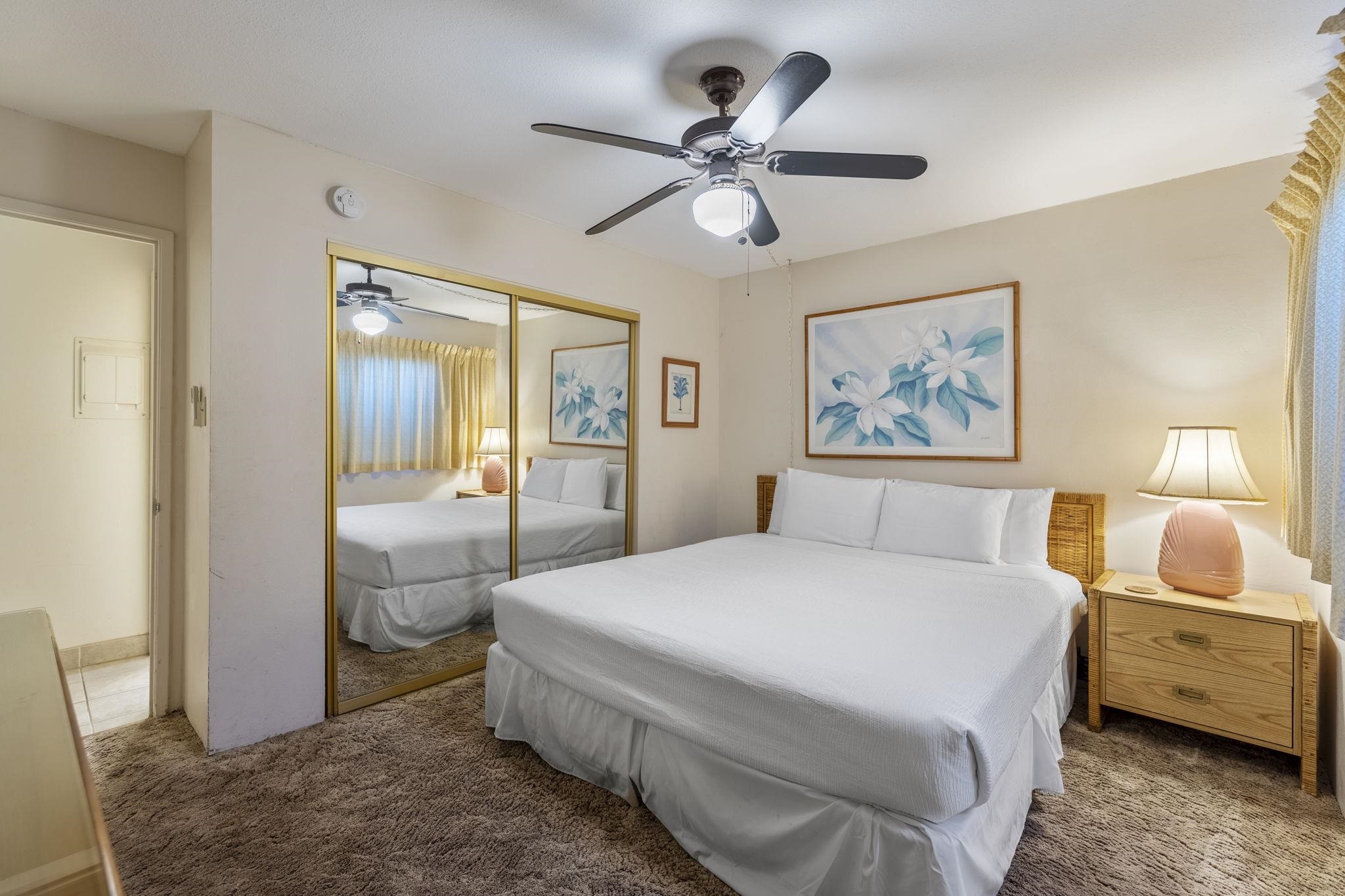 2495 South Kihei Road, Unit 120 Kihei, HI 96753 - Photo 15 of 40 a bedroom with a bed and a chandelier