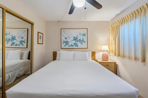 a bedroom with a large bed and a painting on the wall