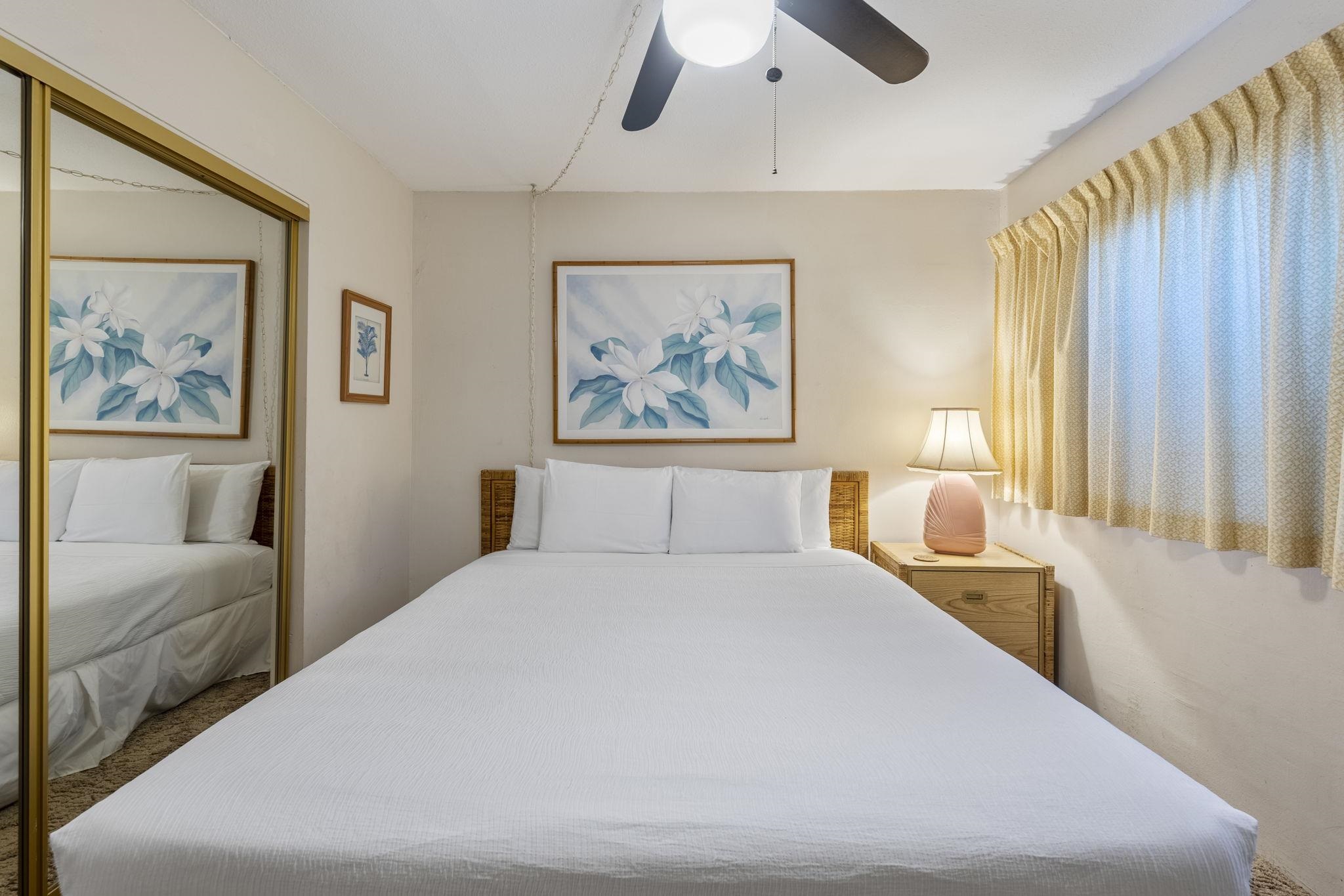 2495 South Kihei Road, Unit 120 Kihei, HI 96753 - Photo 17 of 40 a bedroom with a large bed and a painting on the wall