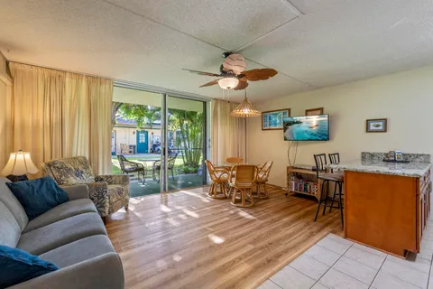 a living room with furniture a flat screen tv and a large window