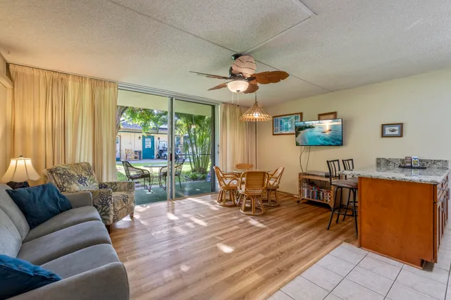 a living room with furniture a flat screen tv and a large window