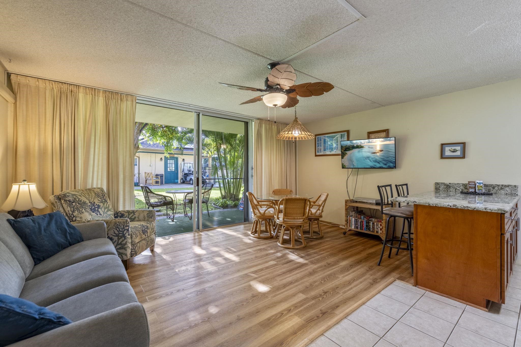 2495 South Kihei Road, Unit 120 Kihei, HI 96753 - Photo 3 of 40 a living room with furniture a flat screen tv and a large window