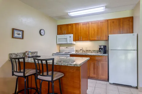 a kitchen with stainless steel appliances granite countertop a refrigerator and a stove top oven
