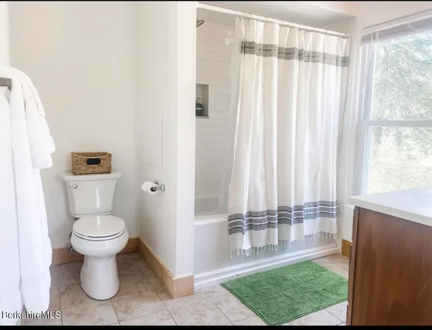 a bathroom with a toilet and a shower curtain