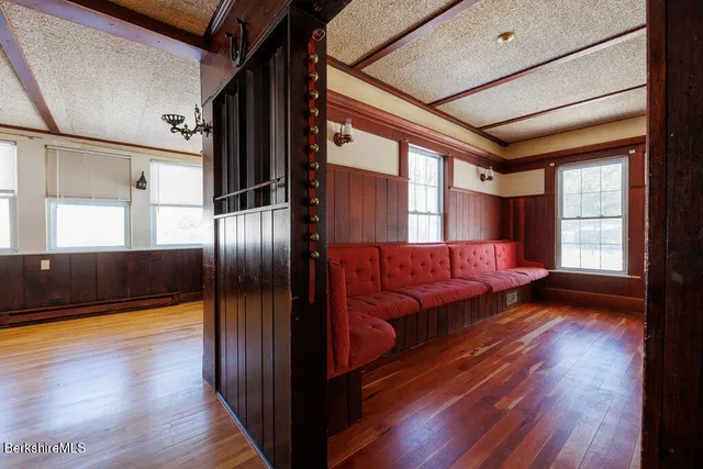 a view of a hallway with wooden floor and stairs