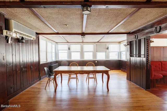 a dining room with furniture a chandelier and wooden floor