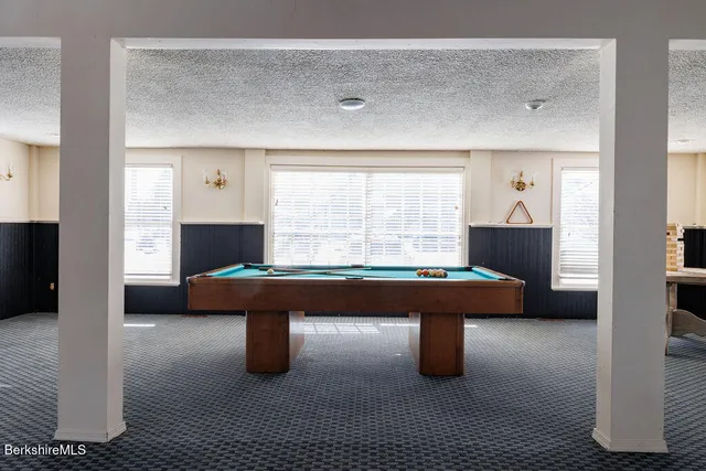 a room with pool table and windows