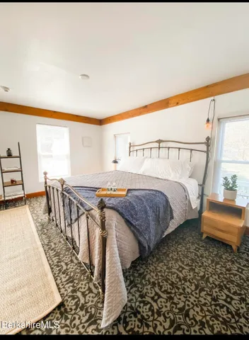 a bedroom with a bed a stove and a large window