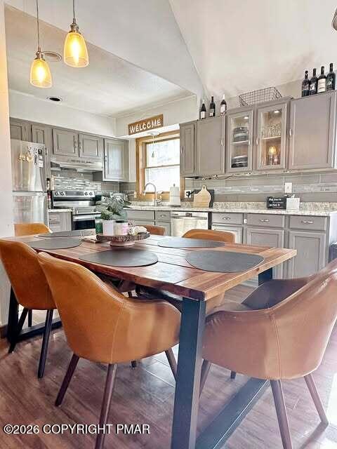 4309 Winchester Way Bushkill, PA 18324 - Photo 40 of 56 a kitchen with stainless steel appliances granite countertop a sink a stove a kitchen island with chairs and wooden floor