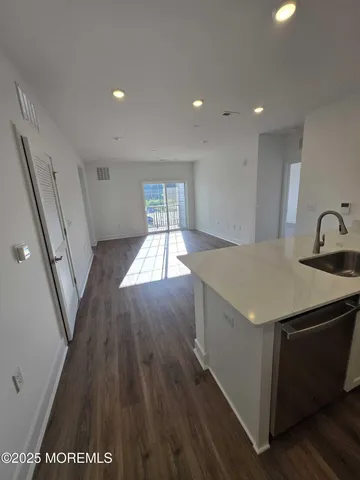 a kitchen with a sink and wooden floor