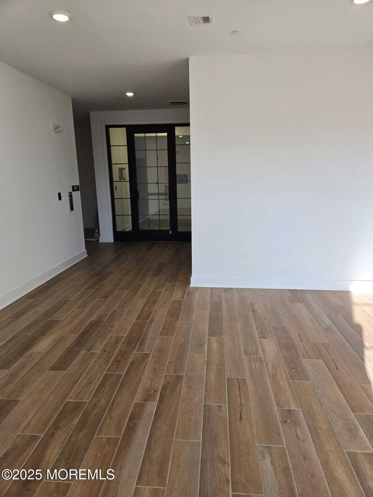 28 Radford Court, Unit 28211 Monroe Township, NJ 08831 - Photo 4 of 33 wooden floor in an empty room with a window