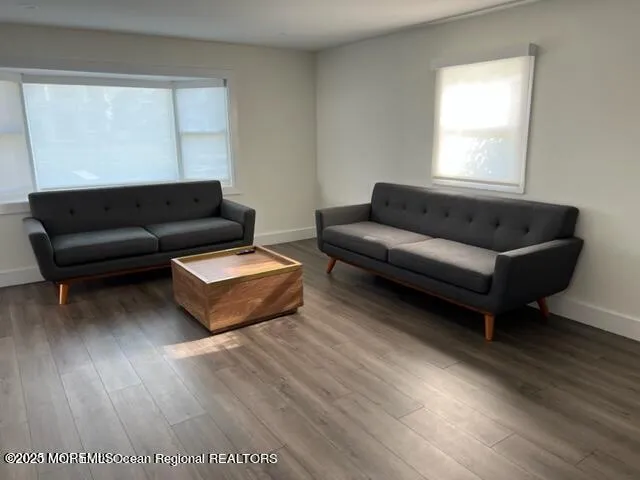 a living room with a couch wooden floor and a window