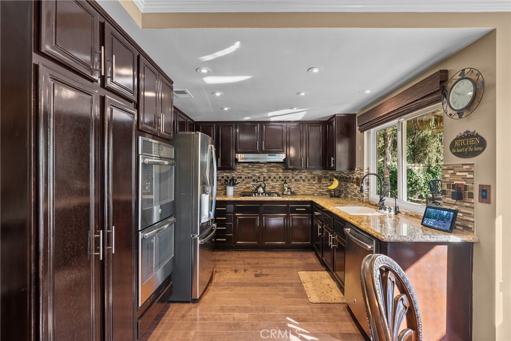 20344 Calhaven Drive Saugus, CA 91390 - Photo 26 of 70 a large kitchen with stainless steel appliances granite countertop a refrigerator and a stove top oven