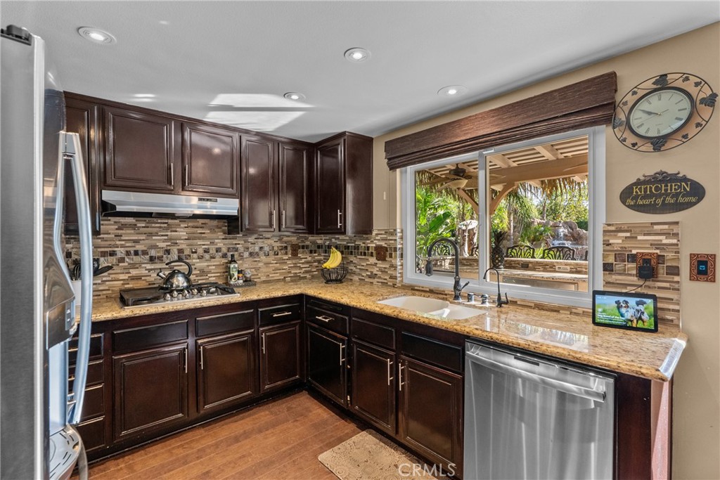 20344 Calhaven Drive Saugus, CA 91390 - Photo 28 of 70 a kitchen with kitchen island granite countertop a sink stove and refrigerator