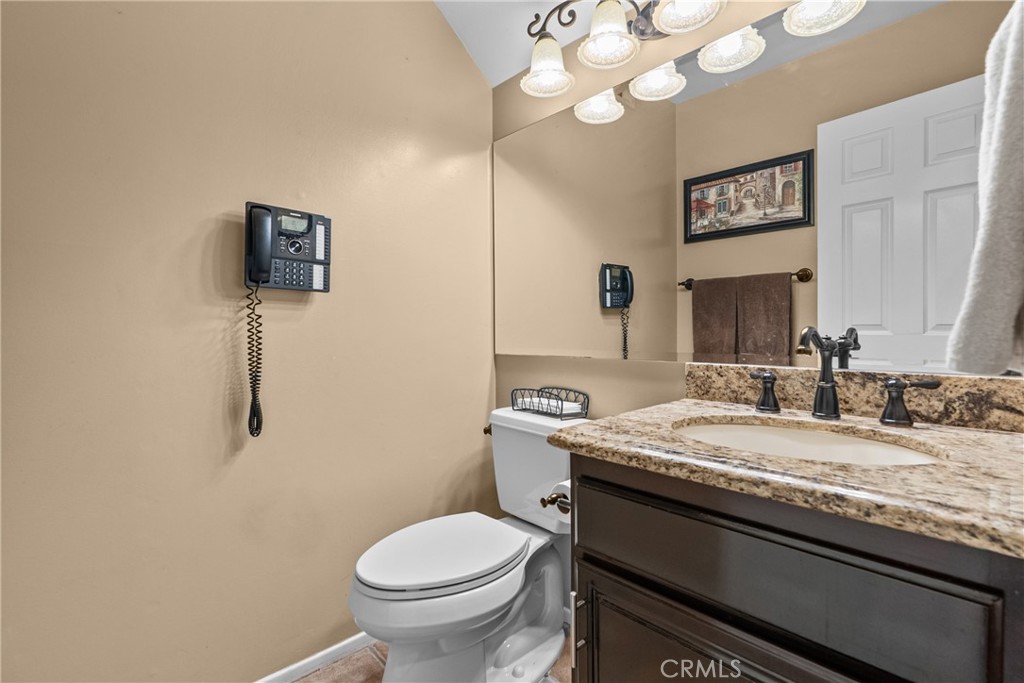 20344 Calhaven Drive Saugus, CA 91390 - Photo 34 of 70 a bathroom with a granite countertop toilet sink and mirror