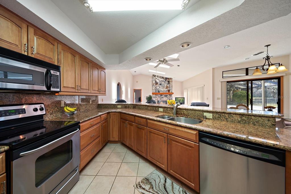 18419 Tyler Road Odessa, FL 33556 - Photo 13 of 38 a kitchen with stainless steel appliances granite countertop a sink stove and microwave