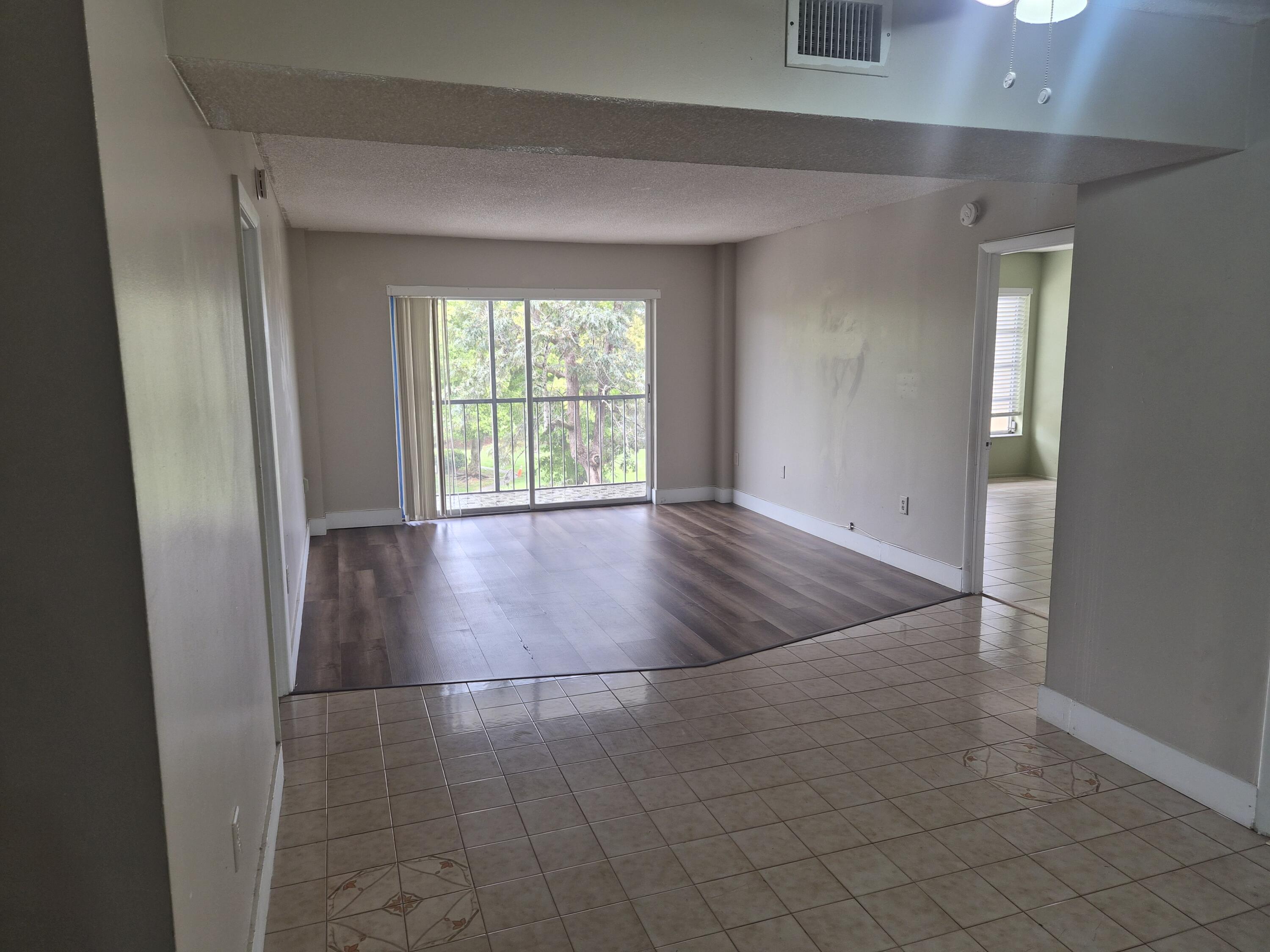 4166 Inverrary Drive, Unit 403 Lauderhill, FL 33319 - Photo 12 of 32 an empty room with wooden floor and windows