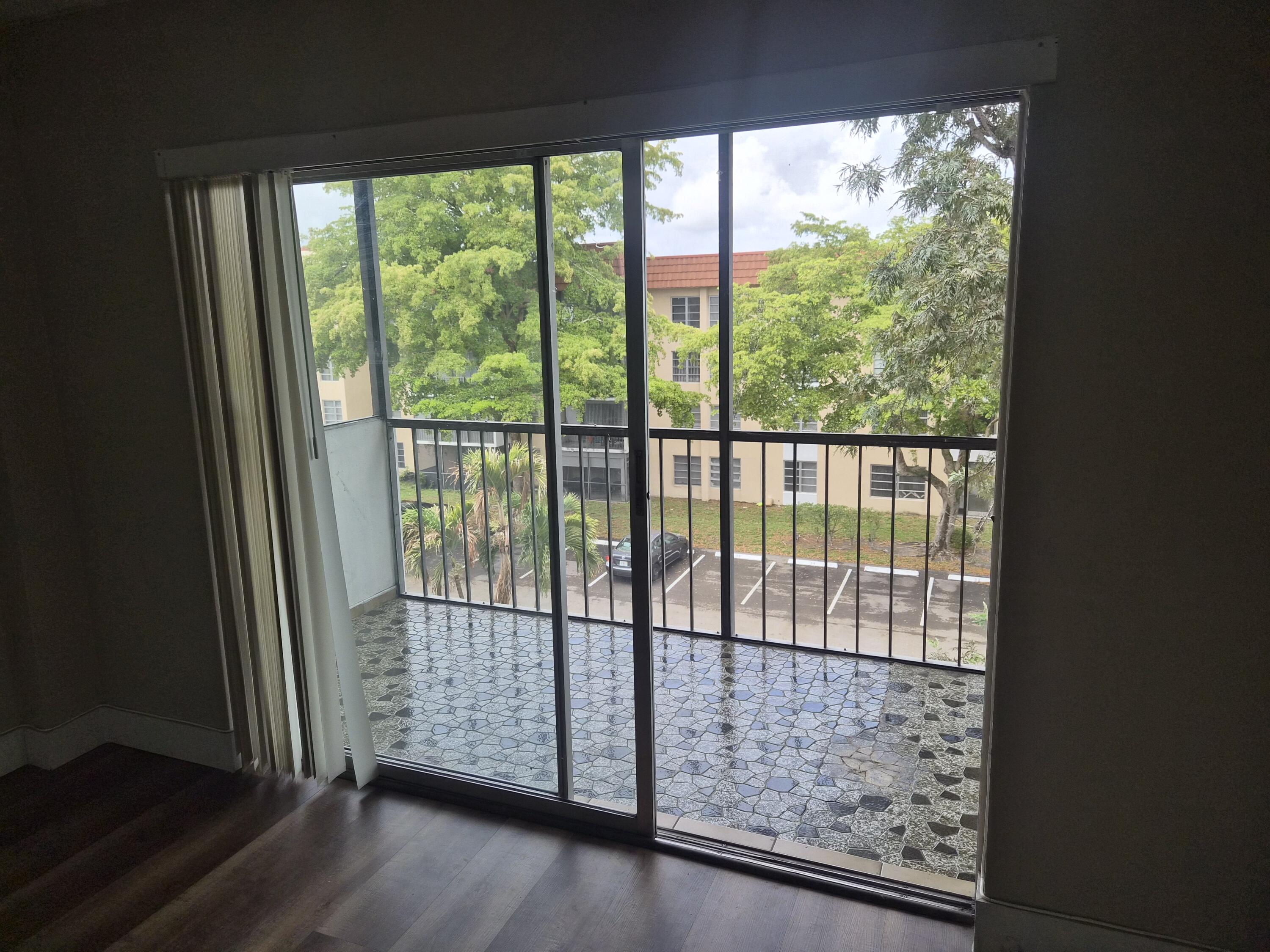 4166 Inverrary Drive, Unit 403 Lauderhill, FL 33319 - Photo 14 of 32 a view of a room with wooden floor and city from a balcony