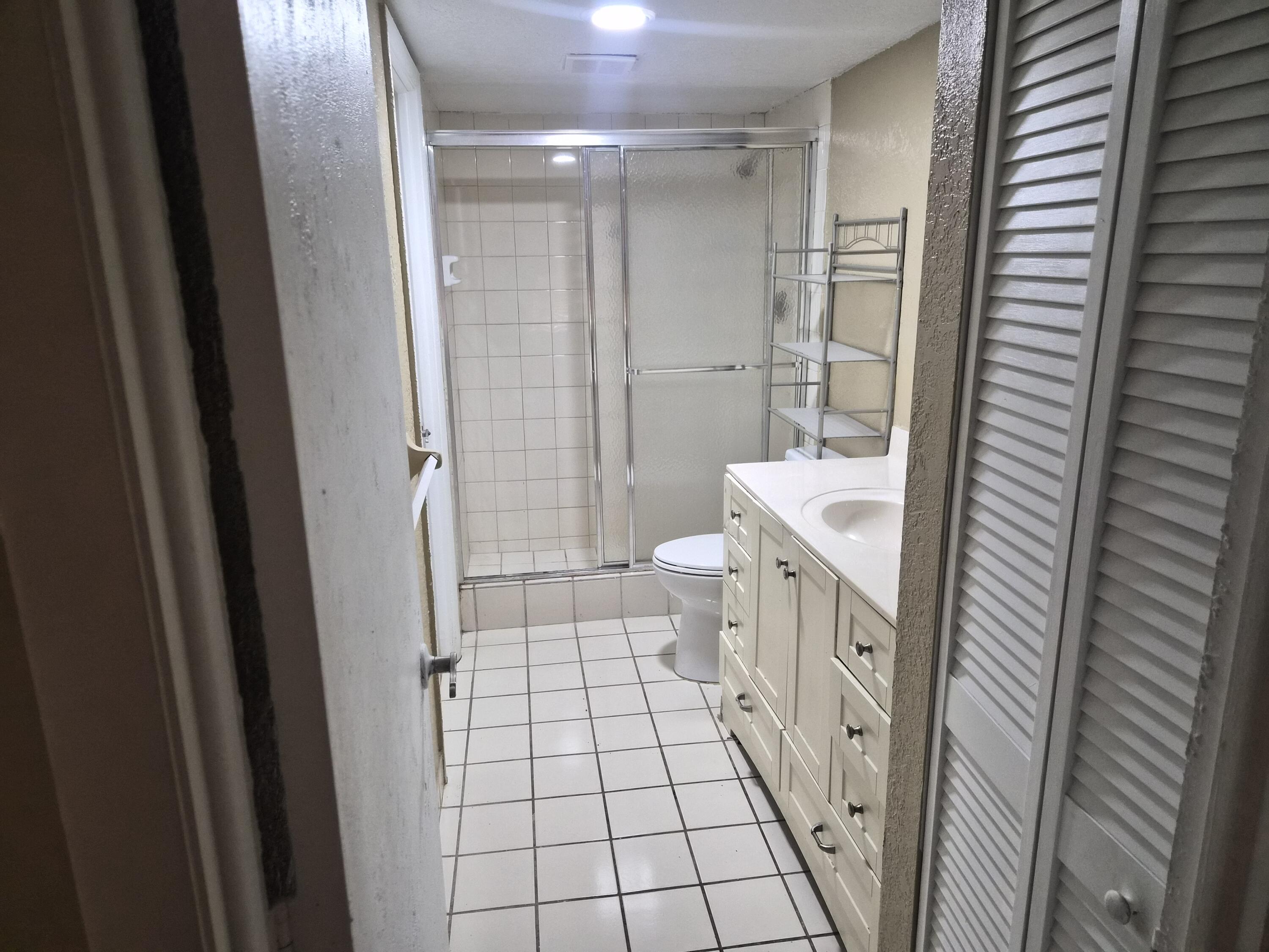 4166 Inverrary Drive, Unit 403 Lauderhill, FL 33319 - Photo 29 of 32 a bathroom with a double vanity sink toilet and shower