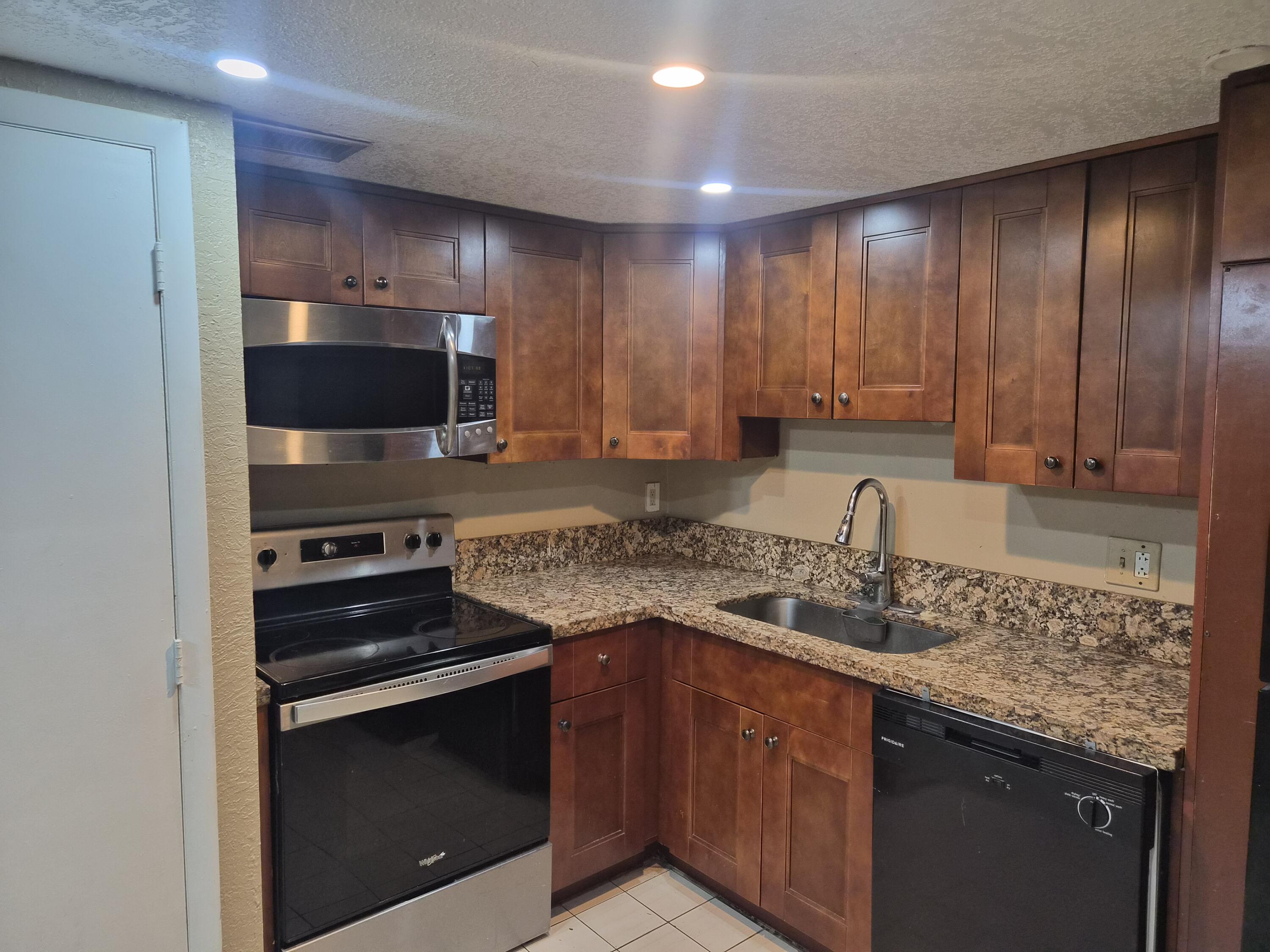 4166 Inverrary Drive, Unit 403 Lauderhill, FL 33319 - Photo 8 of 32 a kitchen with a sink stove and microwave