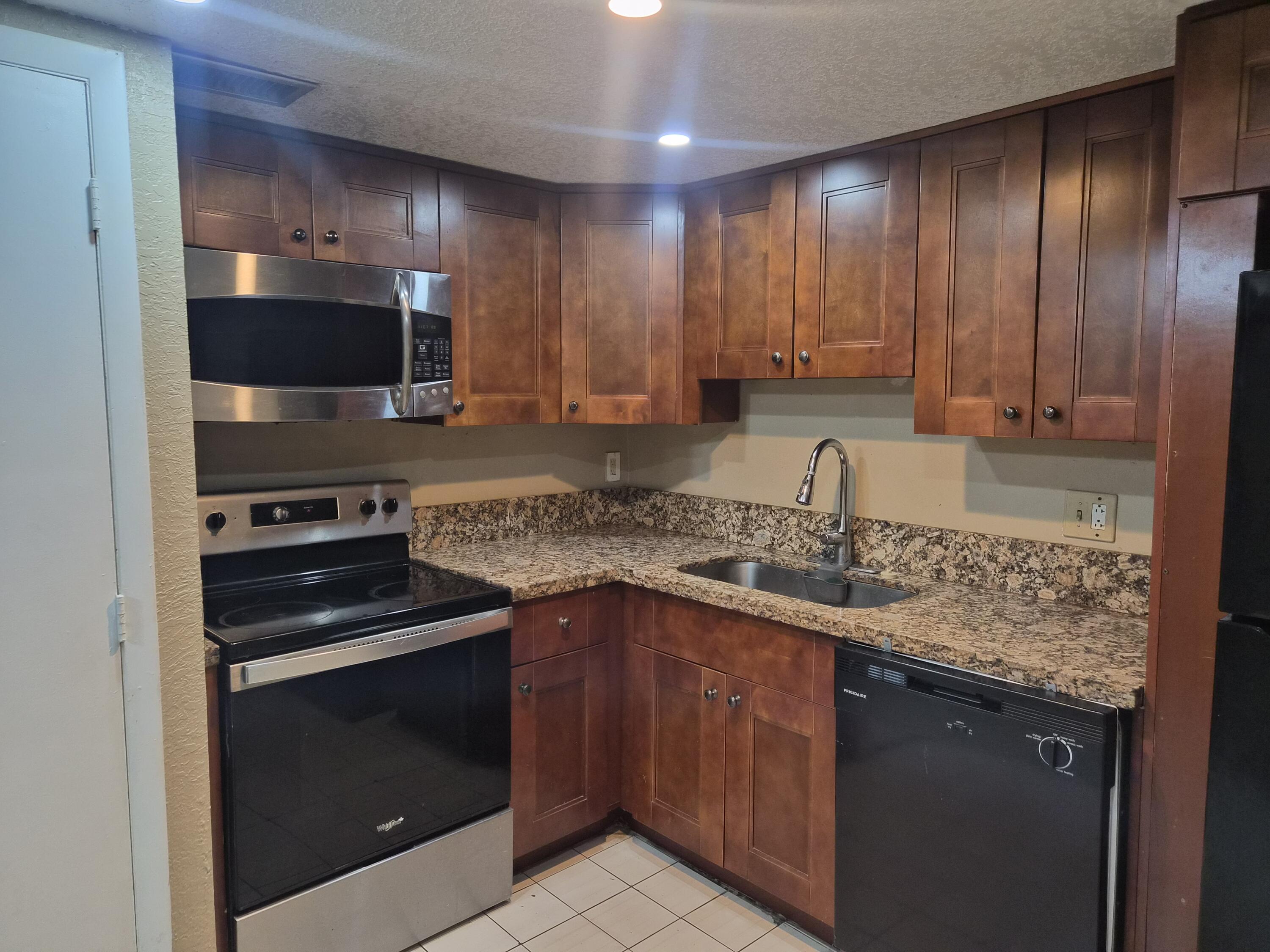 4166 Inverrary Drive, Unit 403 Lauderhill, FL 33319 - Photo 9 of 32 a kitchen with a sink stove and microwave