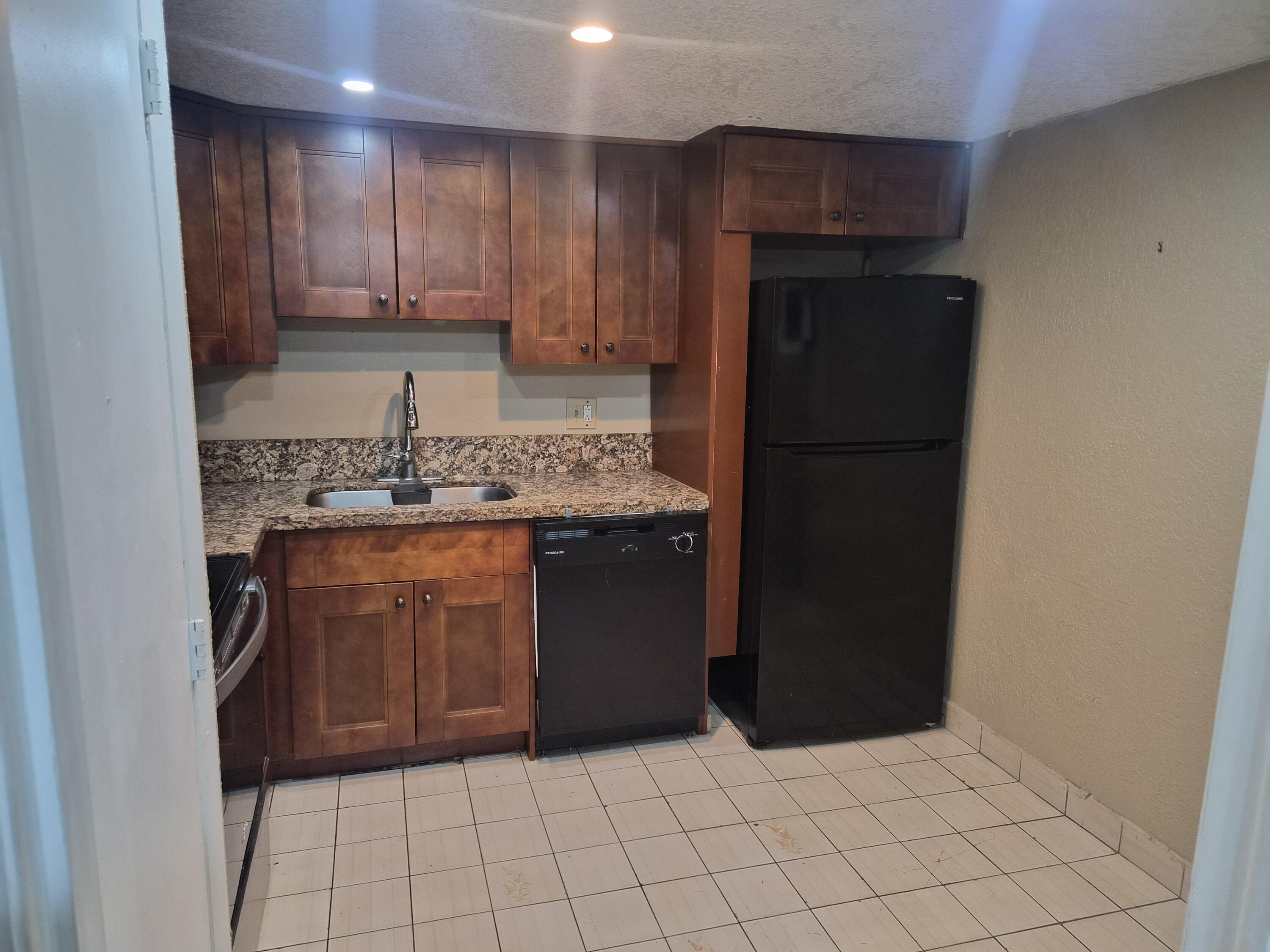 4166 Inverrary Drive, Unit 403 Lauderhill, FL 33319 - Photo 10 of 32 a kitchen with a refrigerator and a sink