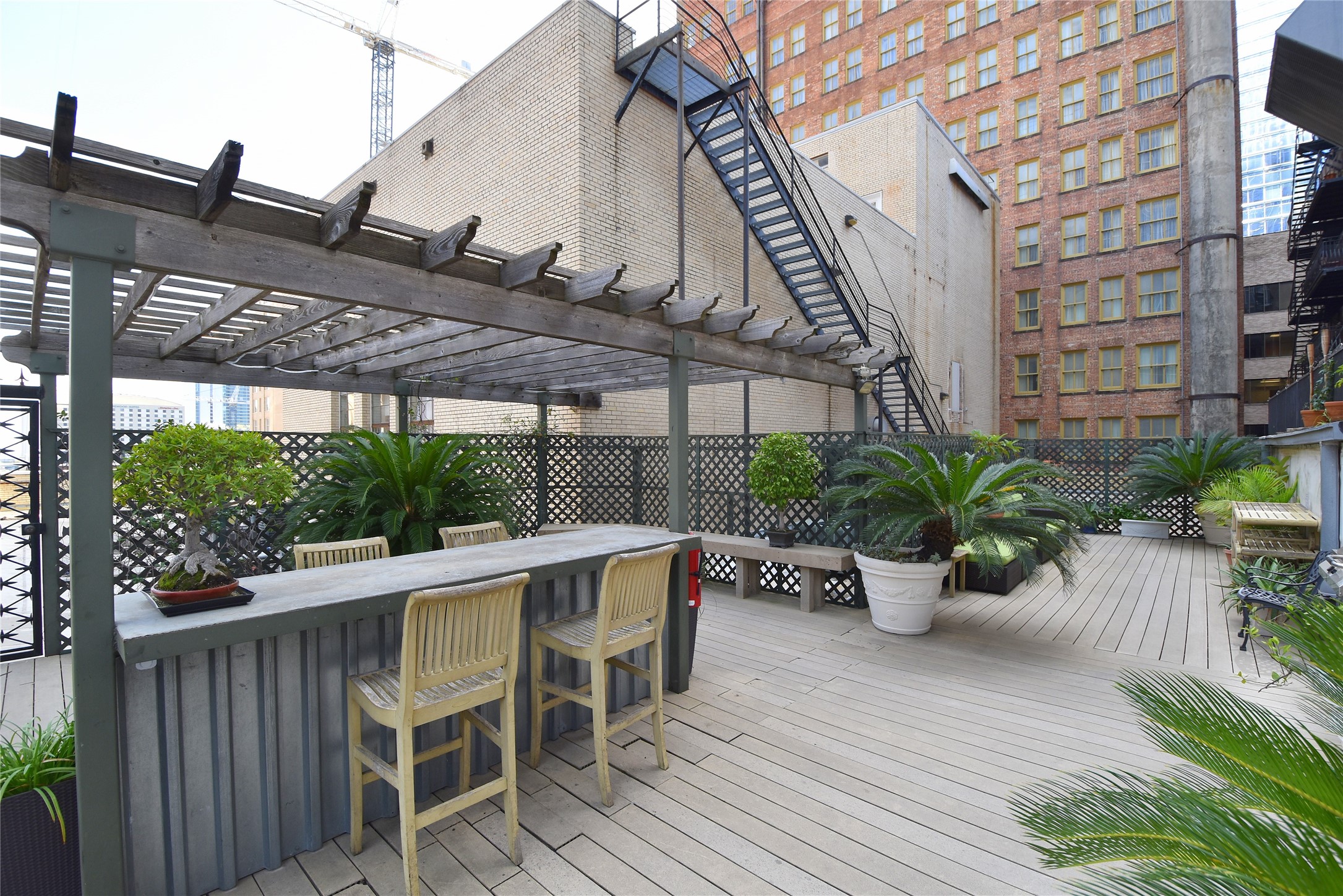 705 Main Street, Unit 215 Houston, TX 77002 - Photo 28 of 36 Spacious urban rooftop deck with a pergola, bar seating.