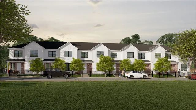 a front view of a house with a yard and green space