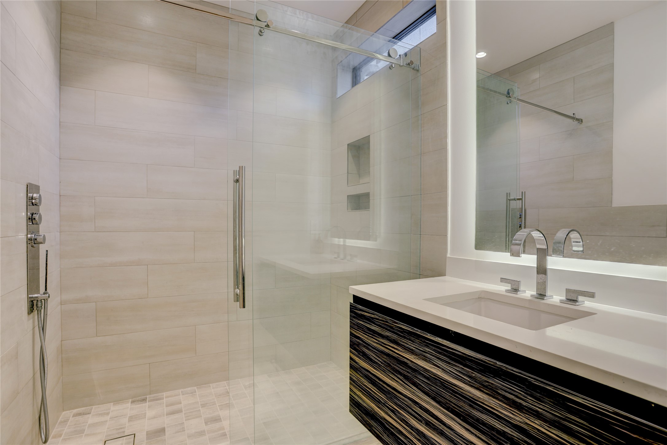 1807 Indiana Street Houston, TX 77006 - Photo 3 of 35 En-Suite Bath: Modern attached bathroom featuring a floating vanity with stone countertops, a backlit LED mirror, and a seamless glass walk-in shower with premium tile and multi-jet spray hardware.