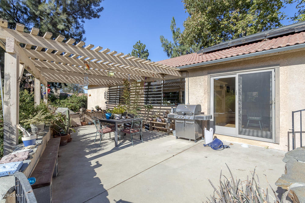 1168 Rambling Road Simi Valley, CA 93065 - Photo 26 of 45 a view of a patio with table and chairs potted plants and floor to ceiling window and wooden floor