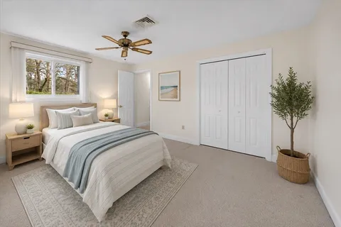 a bedroom with a bed and a potted plant