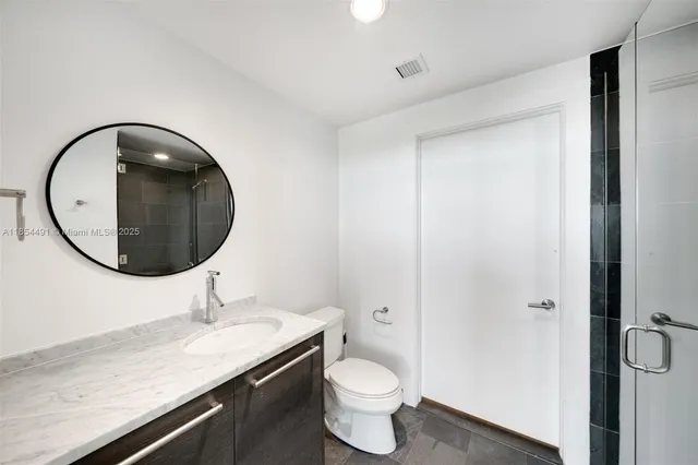 a bathroom with a toilet a sink and mirror