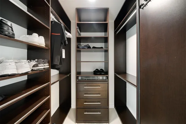 a view of walk in closet with empty racks