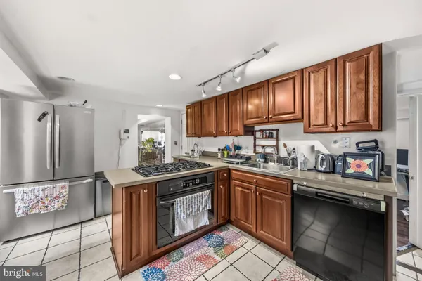 a kitchen with stainless steel appliances granite countertop a stove a sink dishwasher and a refrigerator