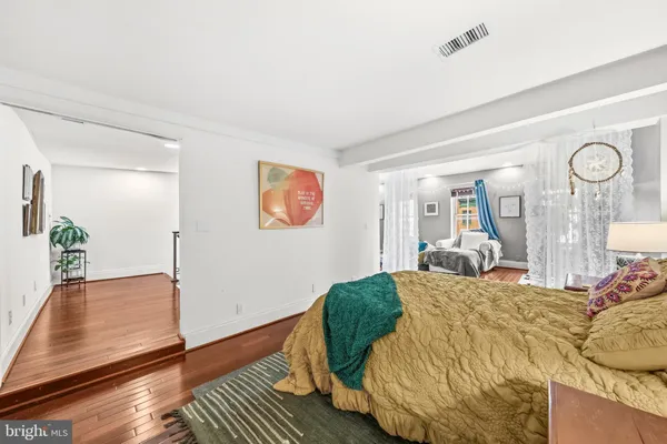 a bedroom with a bed lamp closet and wooden floor