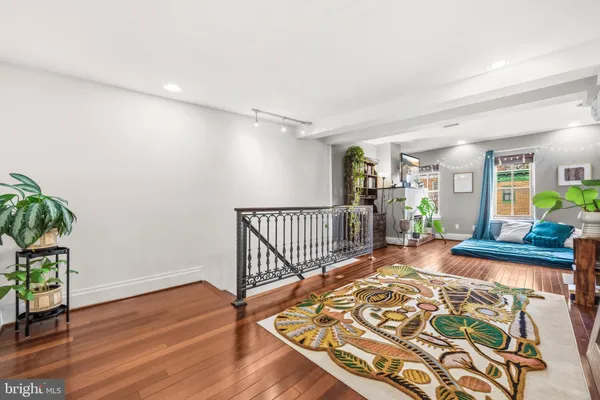 a view of a hallway with wooden floor and a potted plant
