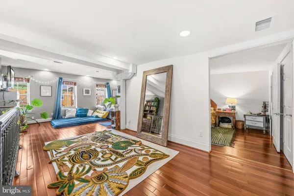 a living room with furniture and a wooden floor
