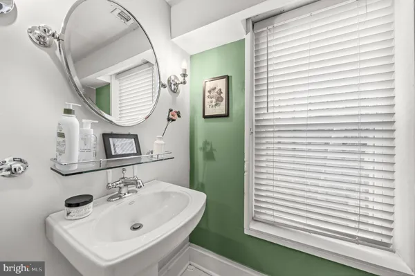 a bathroom with a sink a mirror and a window